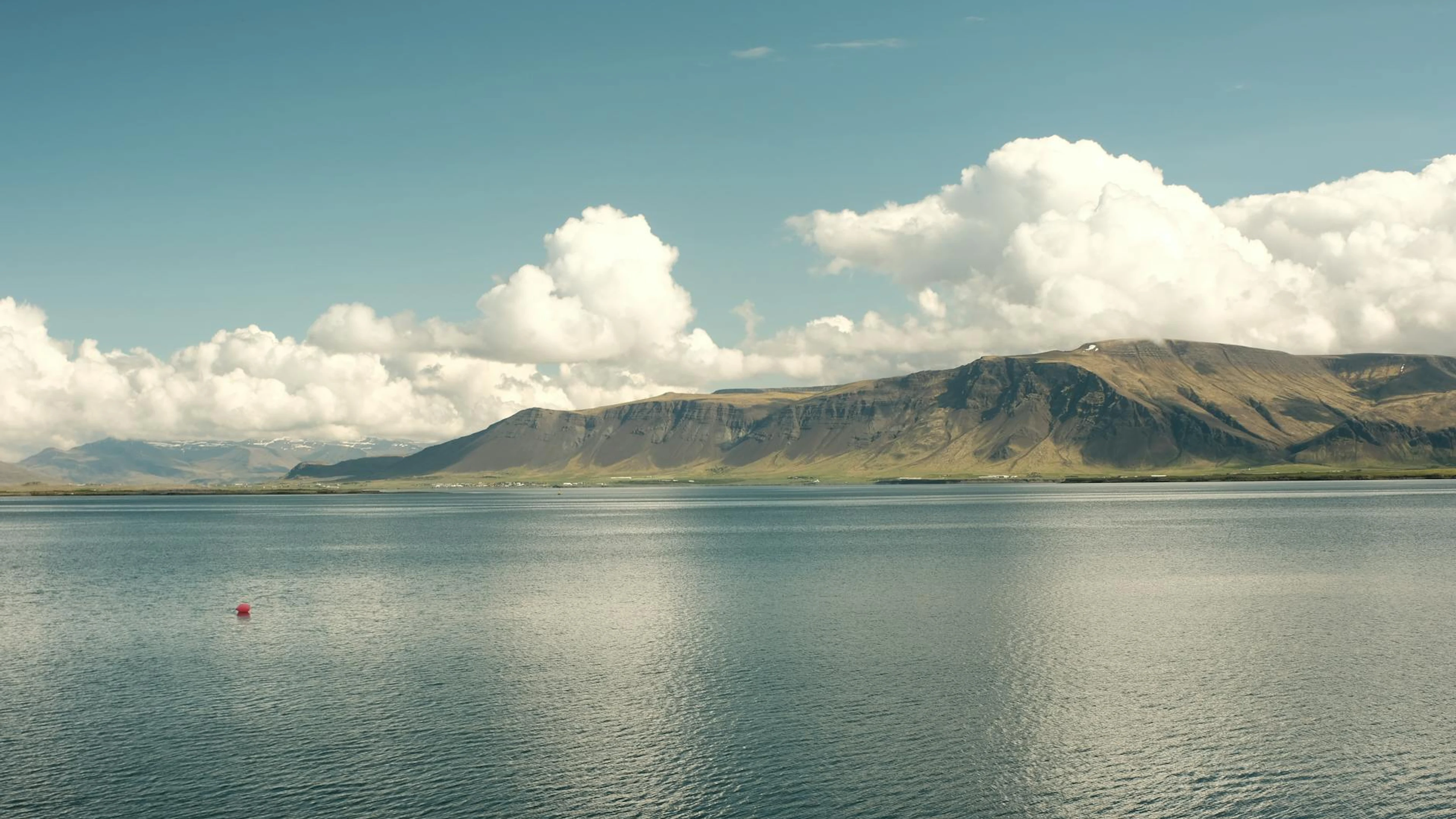 Breathtaking view of Mount Esja with clouds over ocean in Reykjavík, Iceland. - free 4K Ultra HD nature wallpaper for desktop