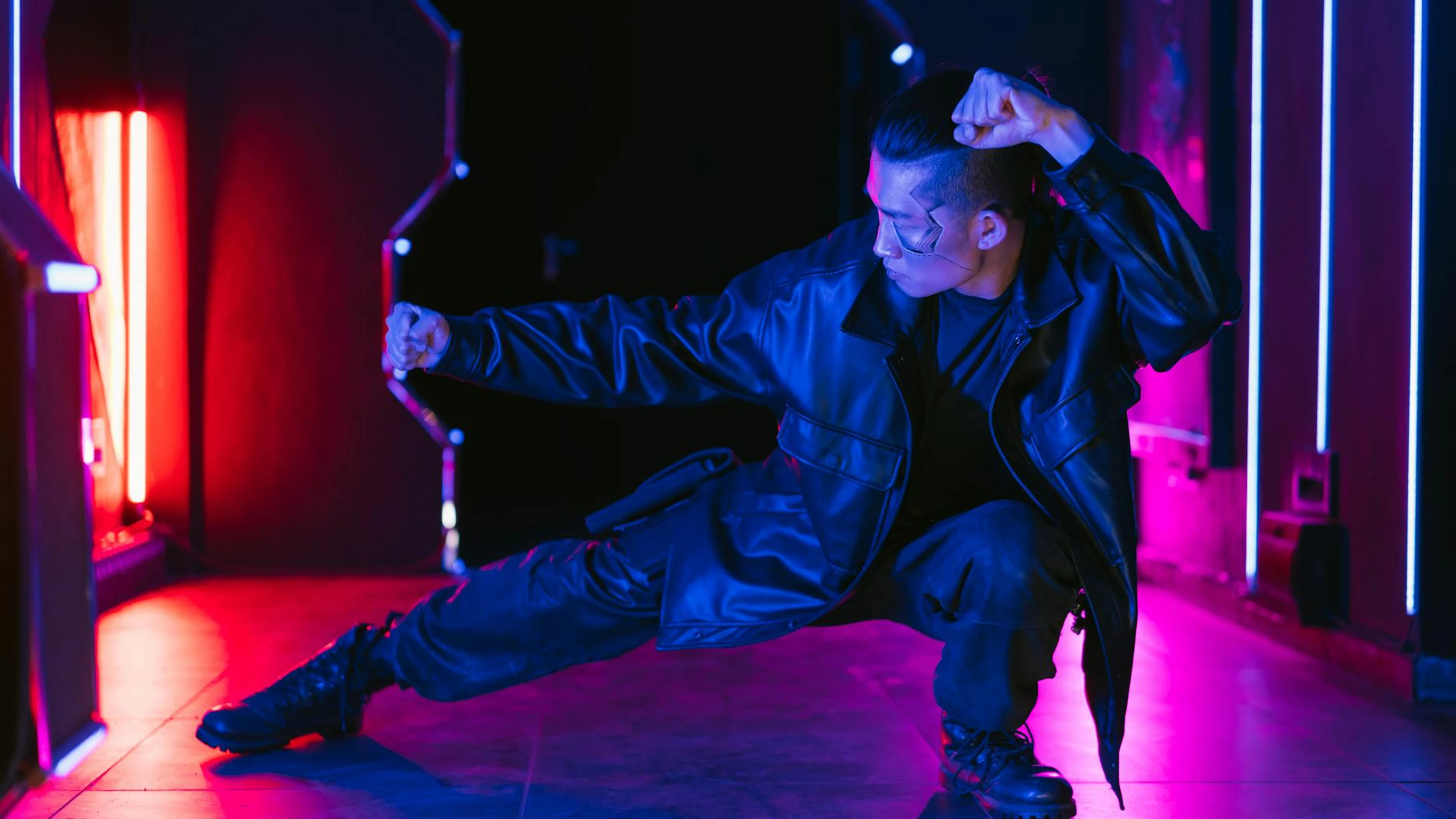 A man in a cyberpunk setting striking a dynamic pose with vibrant neon lighting. - free 4K Ultra HD neon wallpaper for desktop