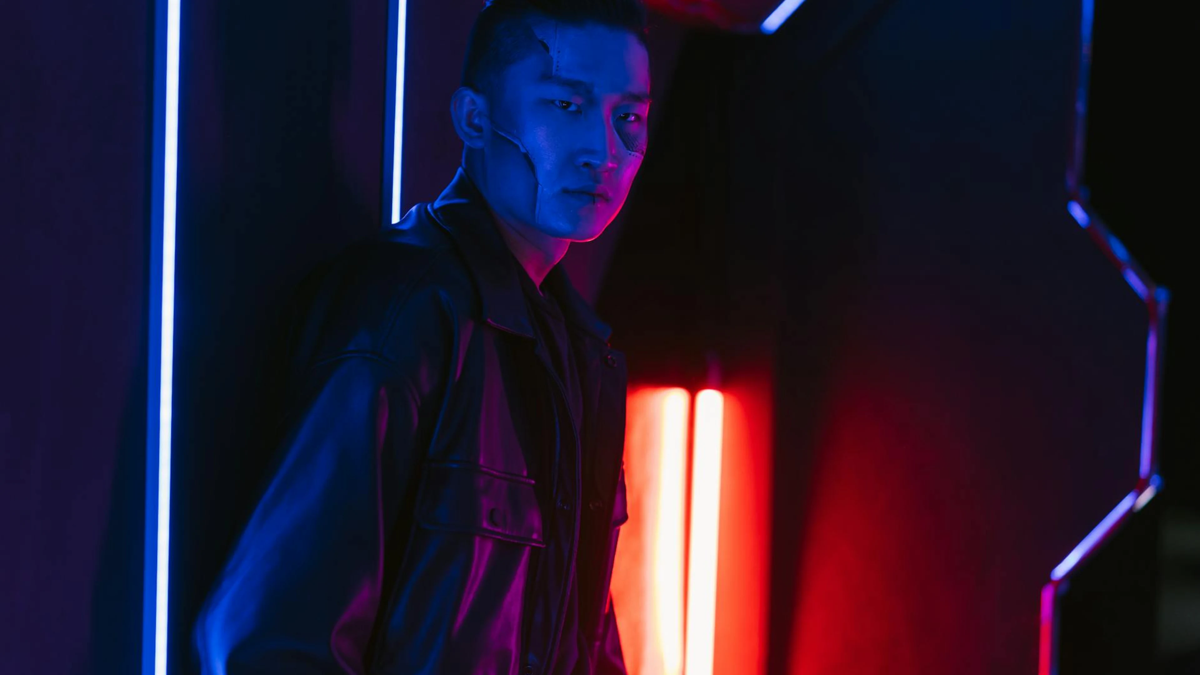 A man in a cyberpunk setting with dramatic neon lighting, exuding a futuristic v - free 4K Ultra HD neon wallpaper for desktop