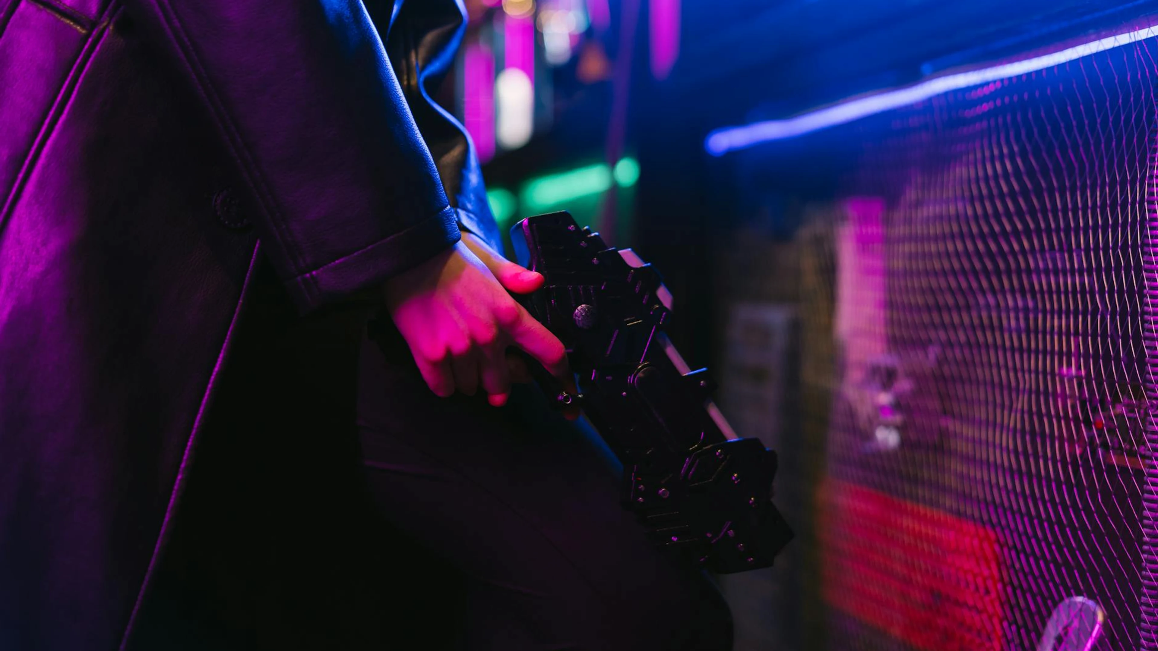 Person holding a futuristic gun with vibrant neon cyberpunk aesthetics. - free 4K Ultra HD neon wallpaper for desktop