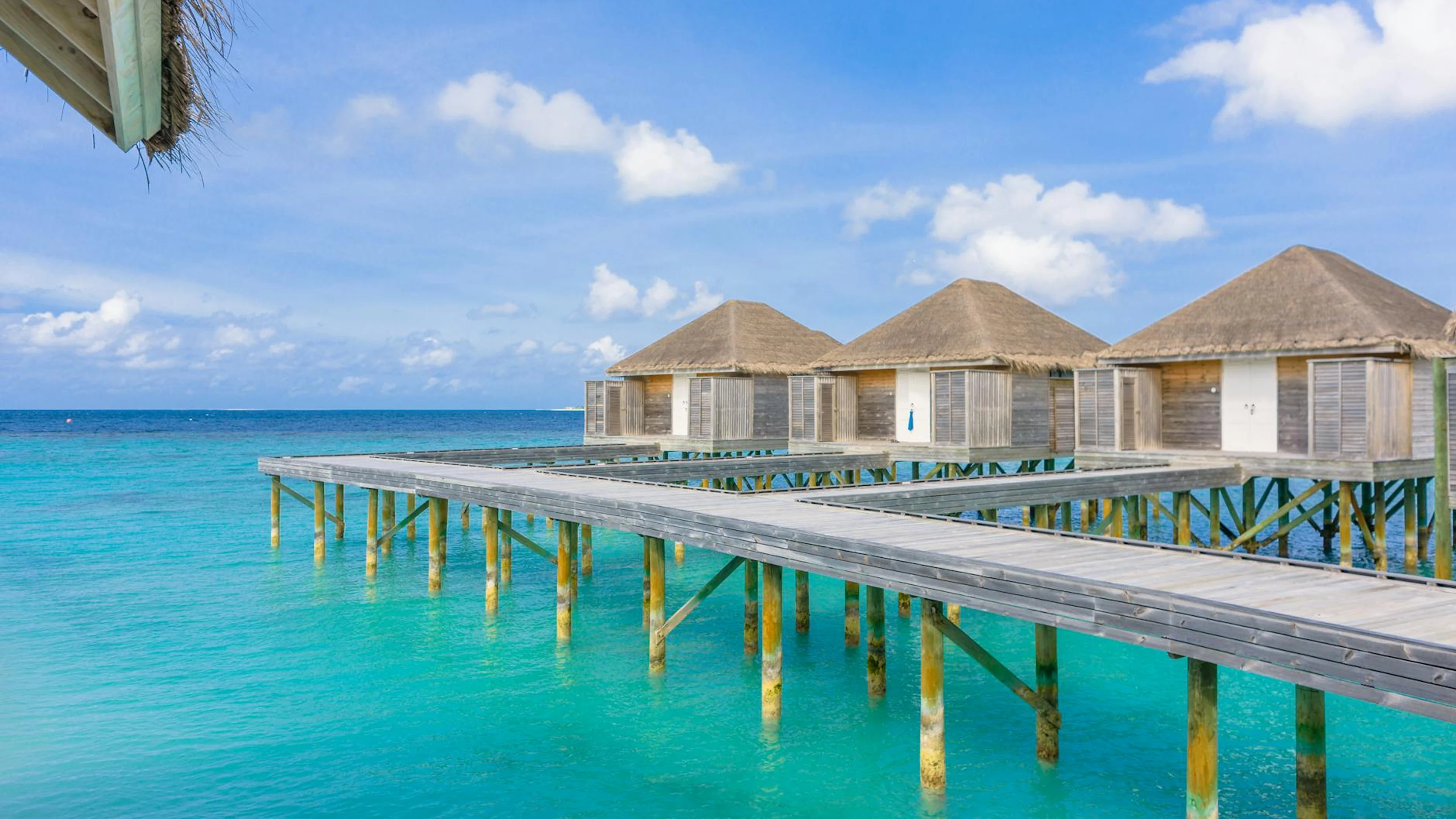Idyllic scene of overwater bungalows in Maldives with turquoise ocean and clear - free 4K Ultra HD ocean wallpaper for desktop