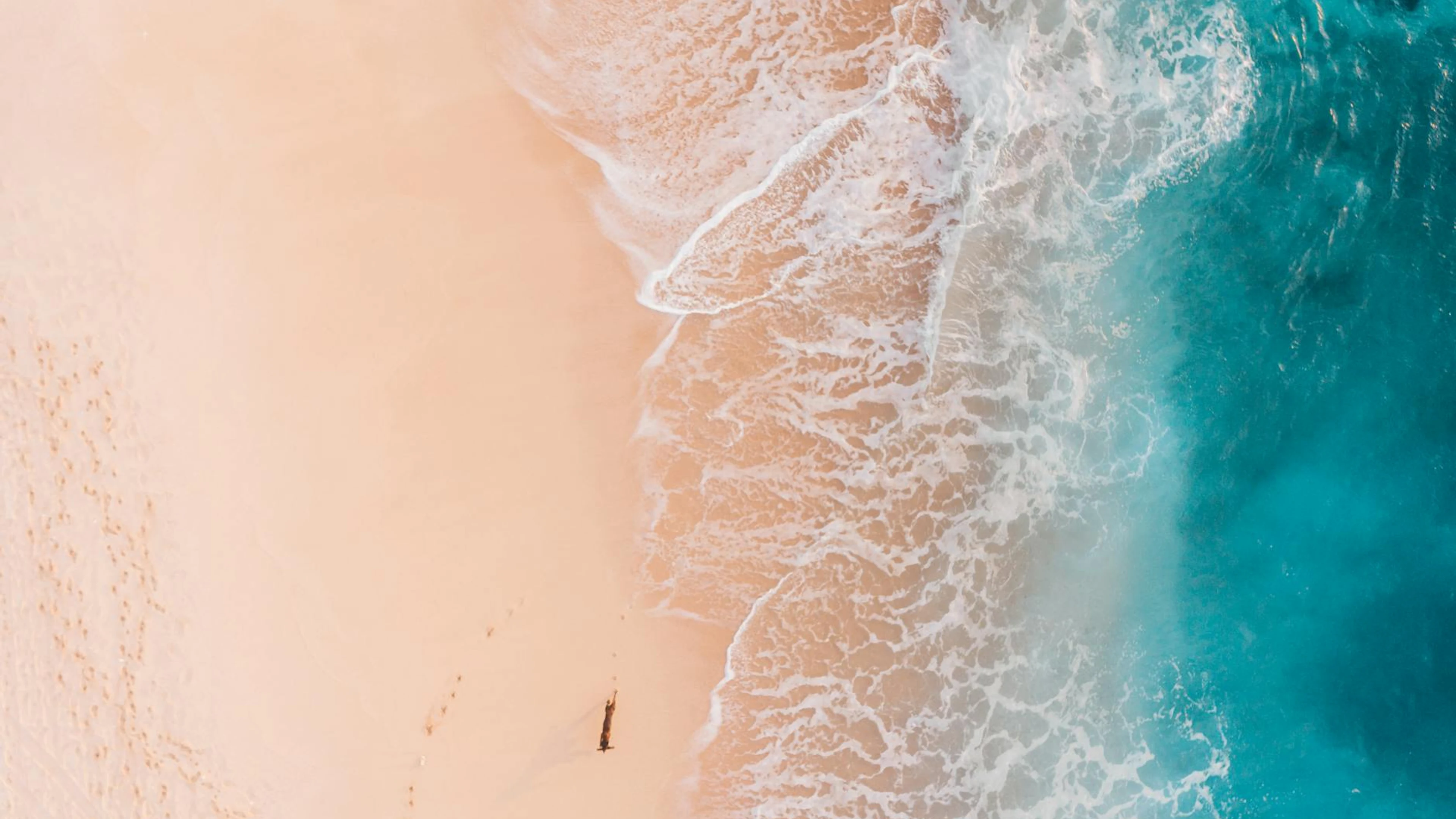 Stunning aerial shot of a sandy beach meeting turquoise ocean waves, perfect for - free 4K Ultra HD ocean wallpaper for desktop