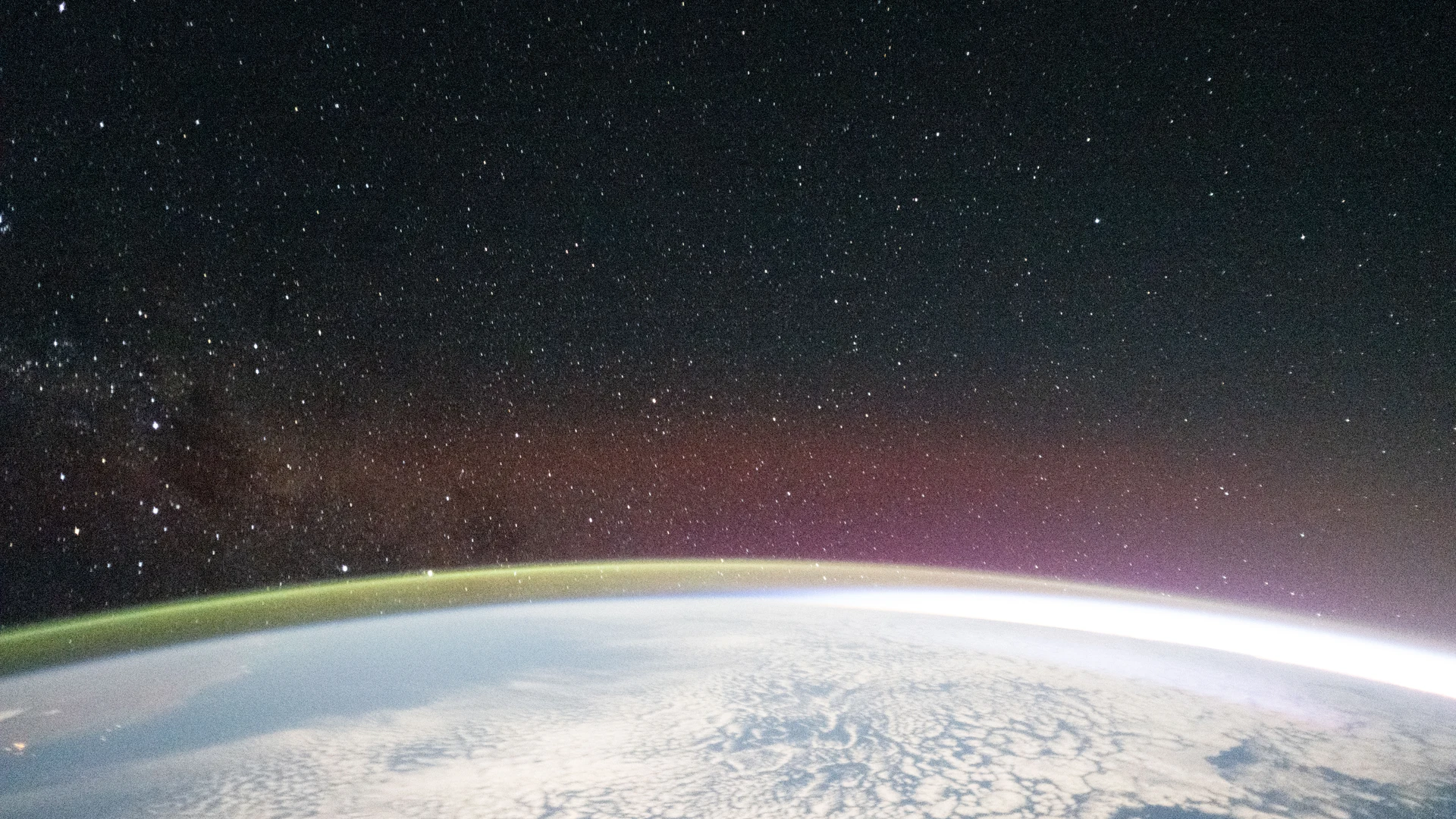 A yellow-green airglow crowns the horizon beneath a starry sky and a faint Milky - free hd space wallpaper for desktop