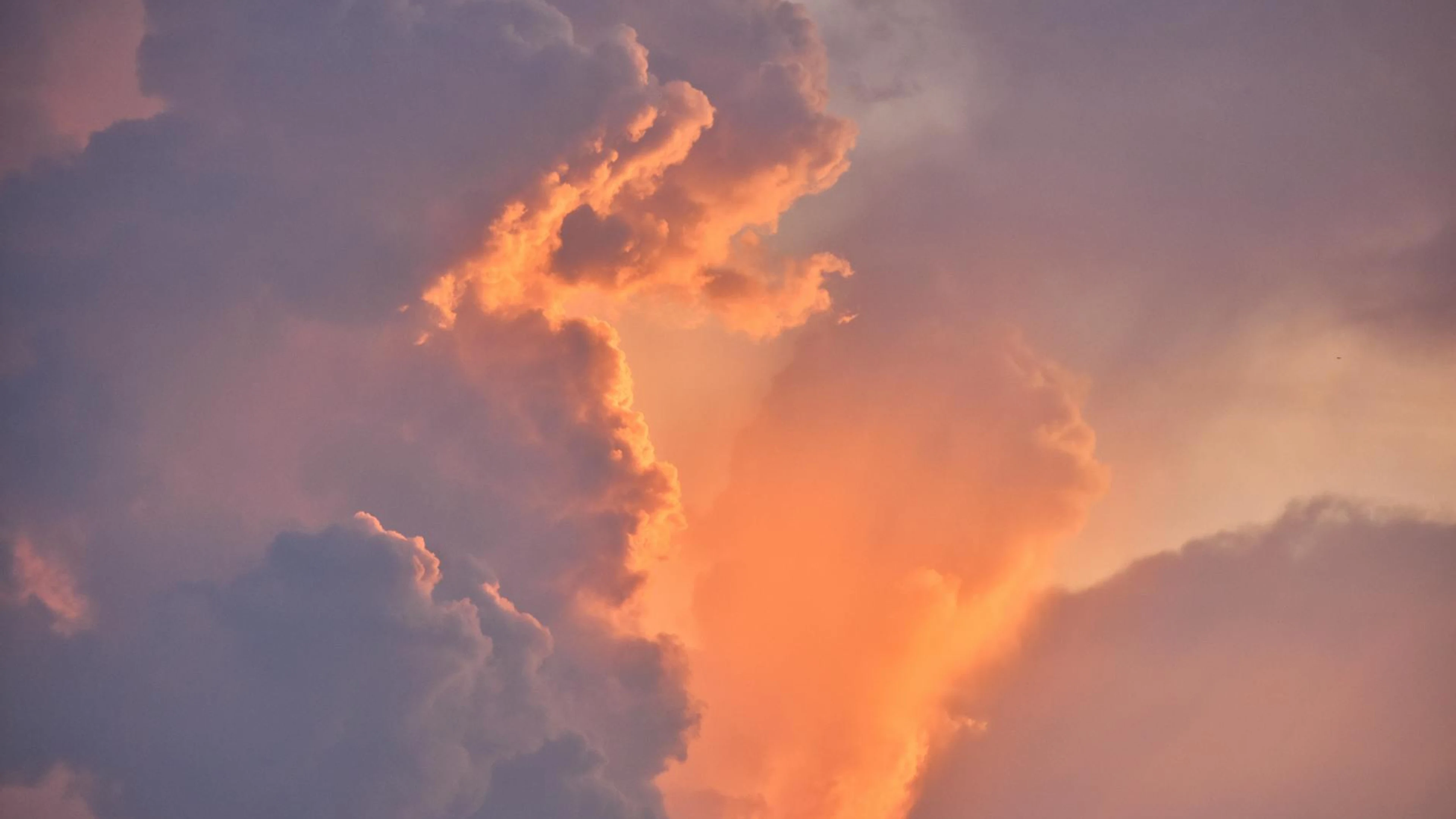 A beautiful display of dramatic sunset clouds with warm colors seen in the sky o - free 4K Ultra HD sunset wallpaper for desktop